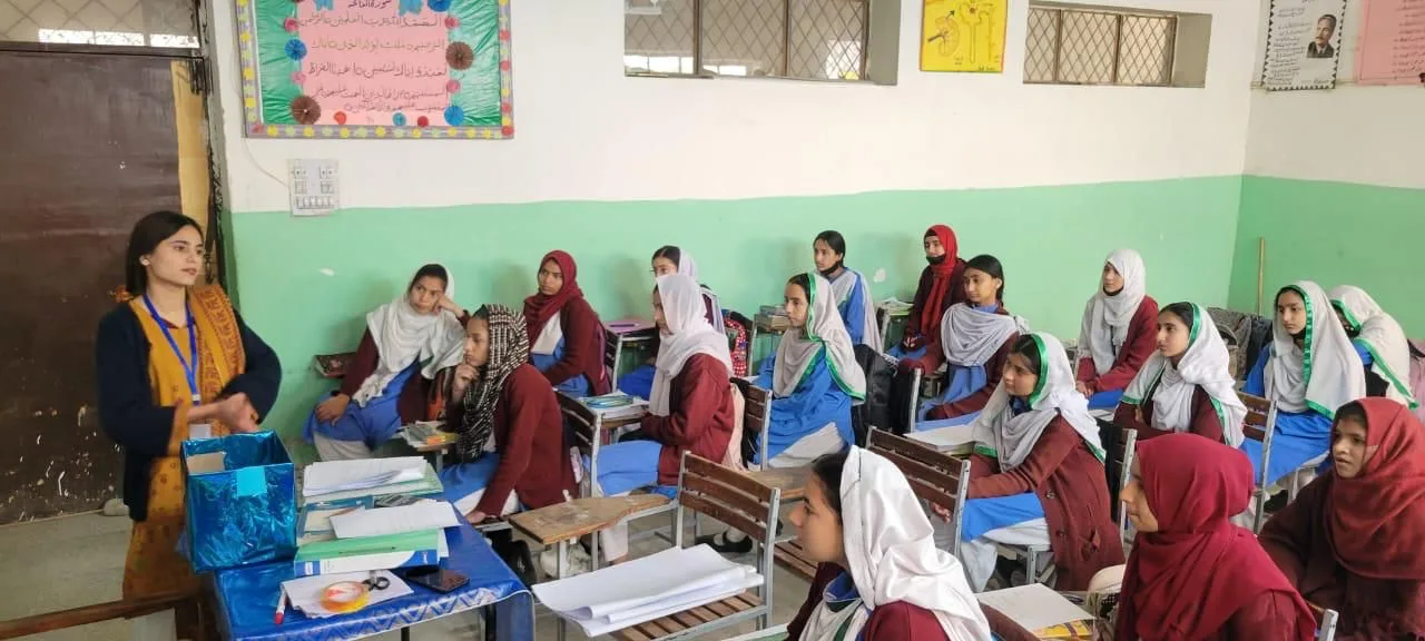 A facilitator leading a Magnificent MEI session with adolescent girls in a government school classroom in Punjab