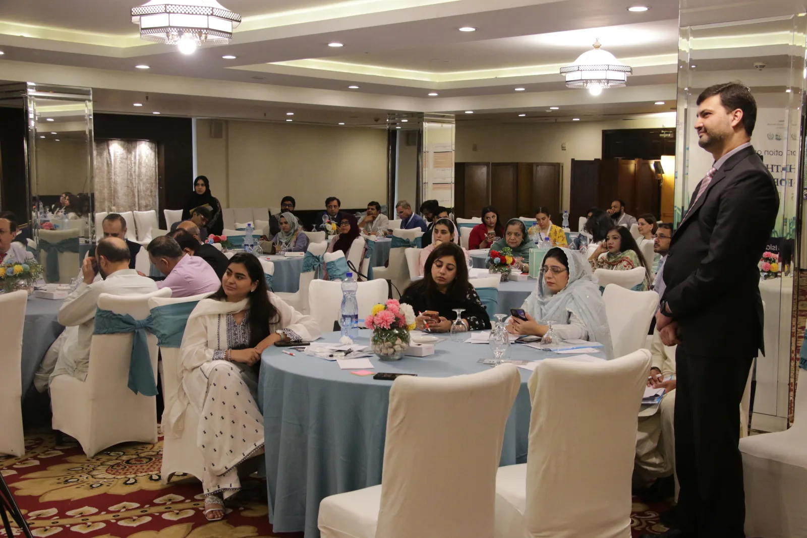 Delegates seated at a RISE consultation session in Islamabad, with a facilitator addressing the room